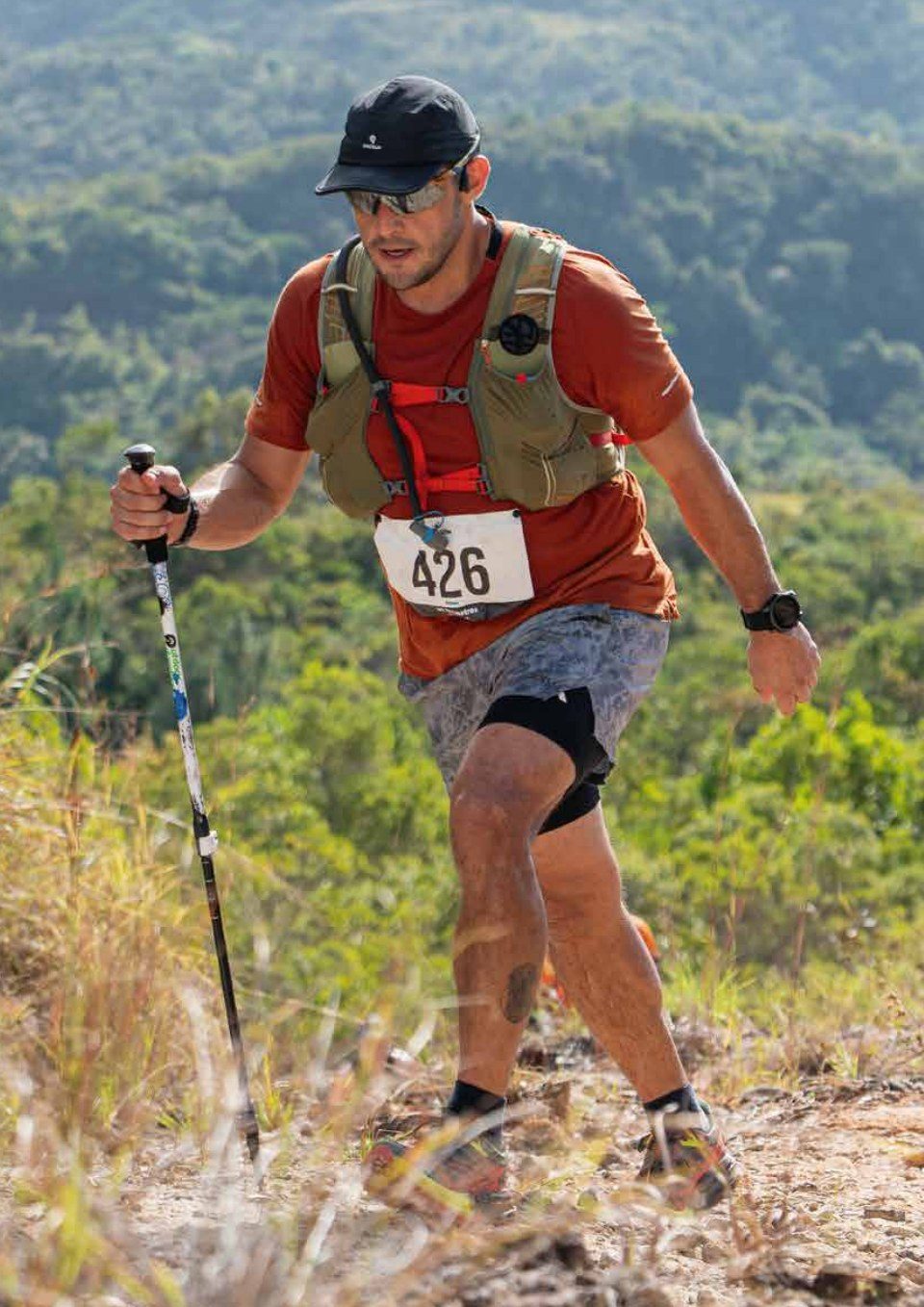 Corredor de trail con gorra Paceup subiendo una montaña